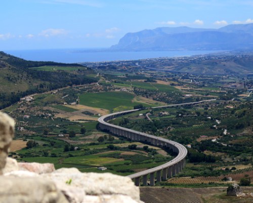 El cálculo infinitesimal de Leibnitz y Newton echó sus raíces en el número Pí que Arquímedes descubrió en Siracusa y ahora permite que crucen Sicilia autopistas perfectas que parecen culebras de plata entre olivos y acantilados, adentrándose hacia Segesta, Selinunte y Agrigento, a lo largo de campos que Virgilio y Goethe amaban y evocaron. Autopistas de presupuestos tan elevados como sus estilizadas pilastras o la orografía abrupta que horadan inquietantes y larguísimos viaductos y túneles equiparables a los de la Italia alpina, cuna de la banca y del capitalismo.
